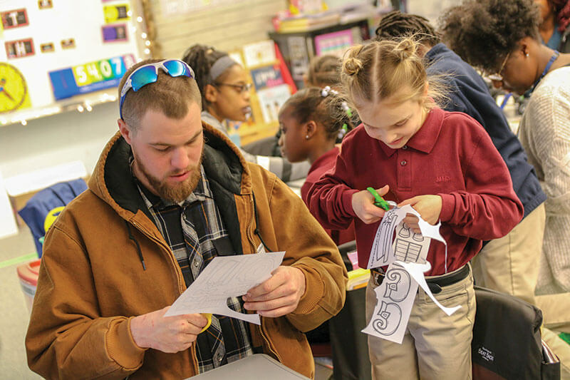 Photo of parent/sponsor and daughter in classroom.