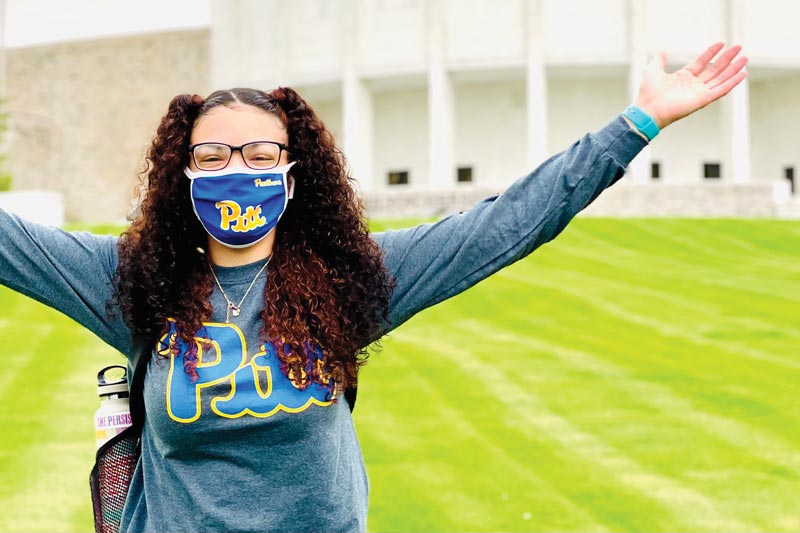 MHS student wearing Pitt College t-shirt in front of Founder's Hall building