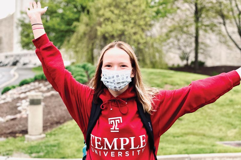 MHS student wearing Temple University sweatshirt in front of Founder's Hall building