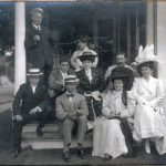 a group of people sitting on the steps of a house