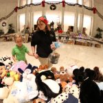 a person and child standing in front of a pile of stuffed animals