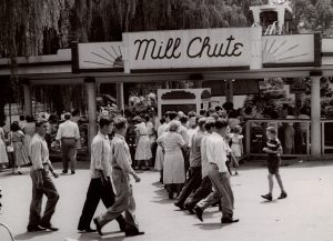 a group of people walking in front of a sign