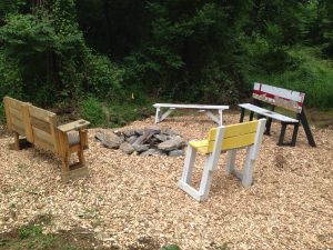 a picnic table and benches in a forest