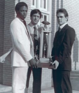 Alumni carrying trophy.