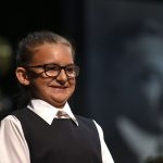 a child wearing glasses and a vest