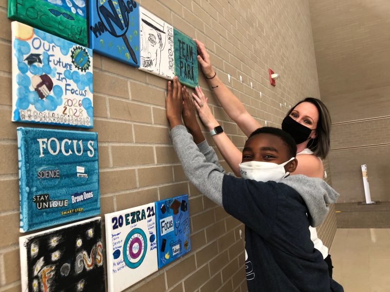 Student and Staff hanging art murals