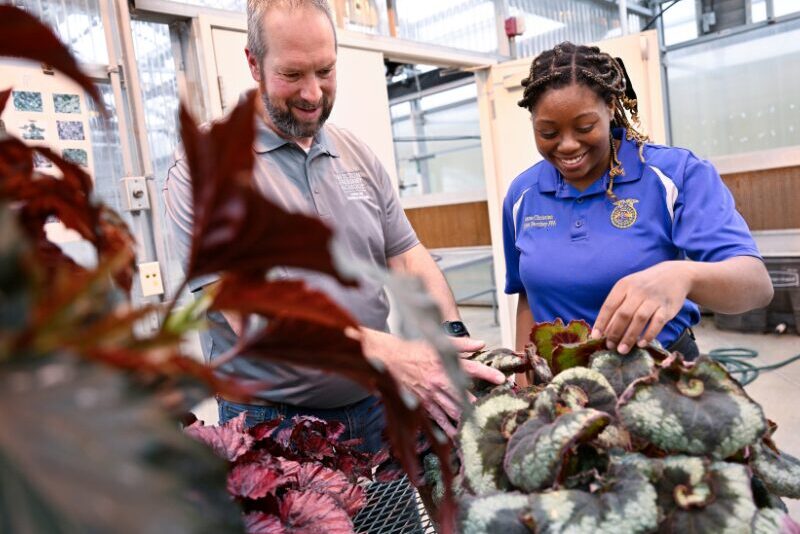 agriculture student tending to a greenhouse