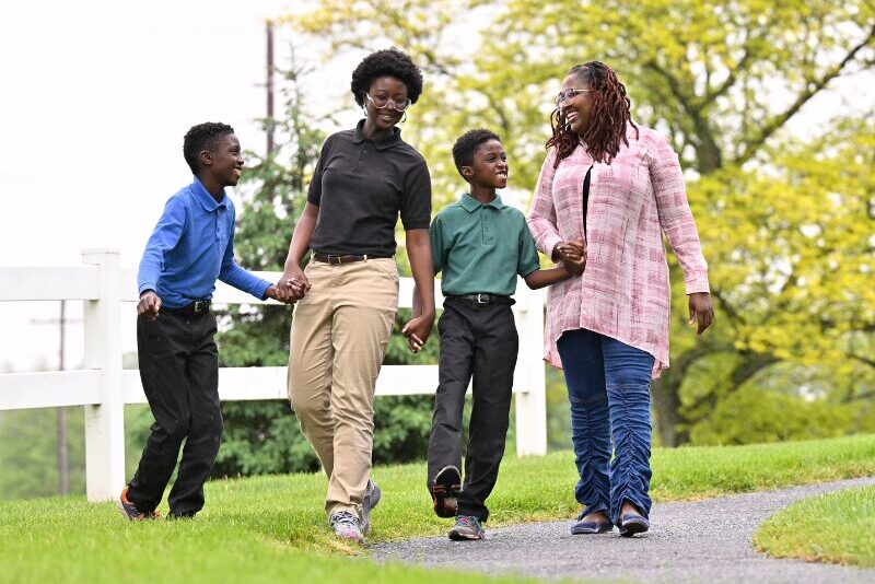 An MHS parent/sponsor walking outside with her children
