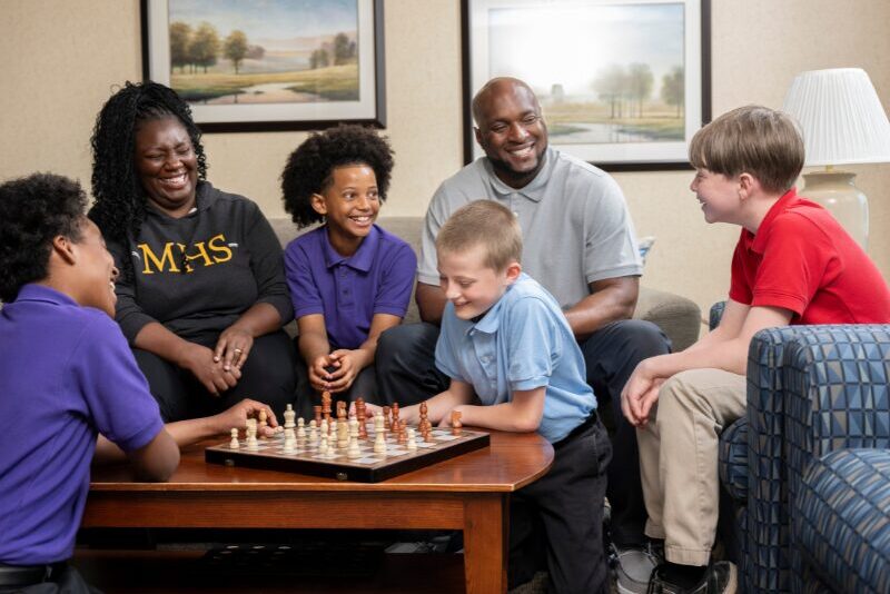 houseparents teaching their students how to play chess