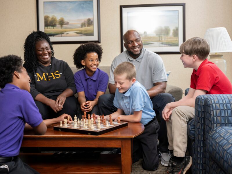 houseparents teaching their students how to play chess