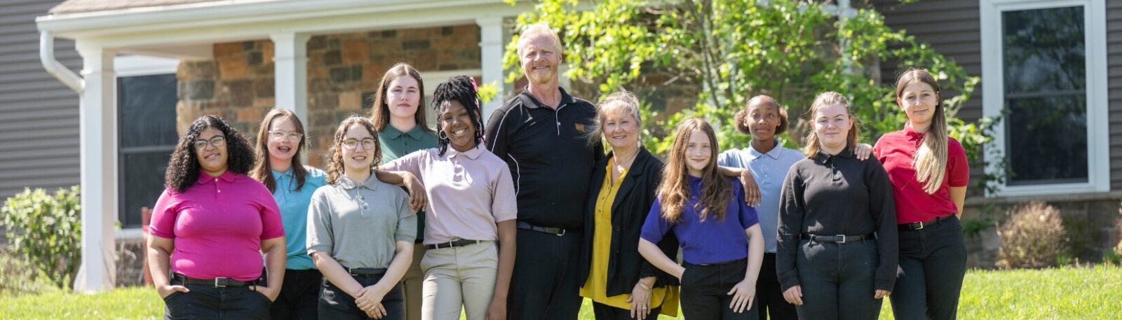 MHS middle division houseparents with their students outside their home