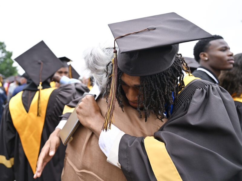 Graduate embraces someone at graduation