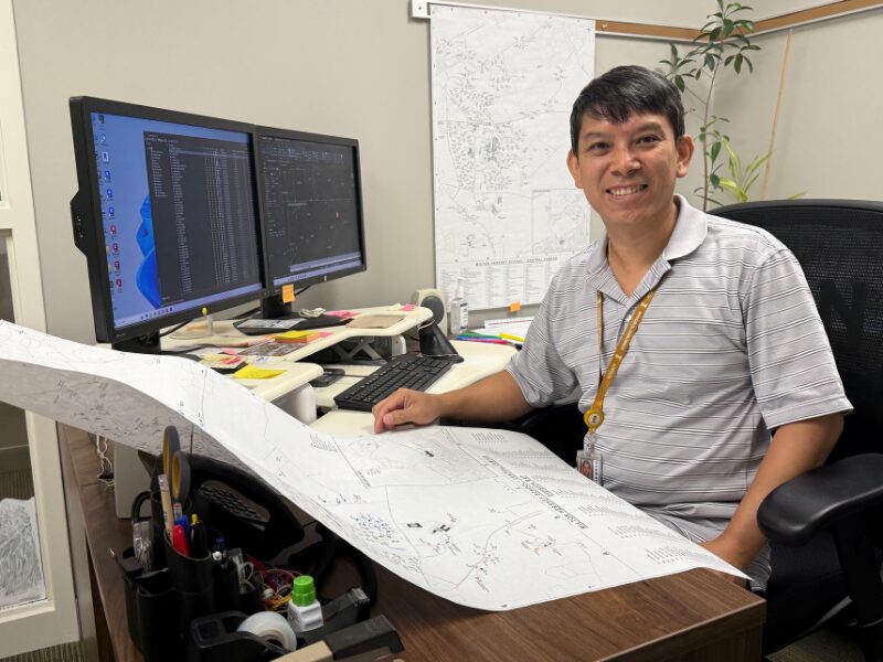 MHS staffer Charles Nguyen at his desk