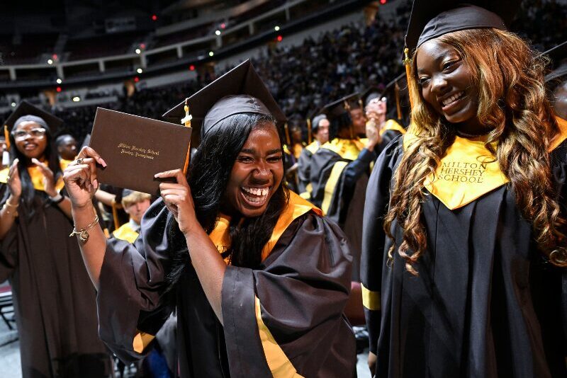 MHS graduate holding up her diploma