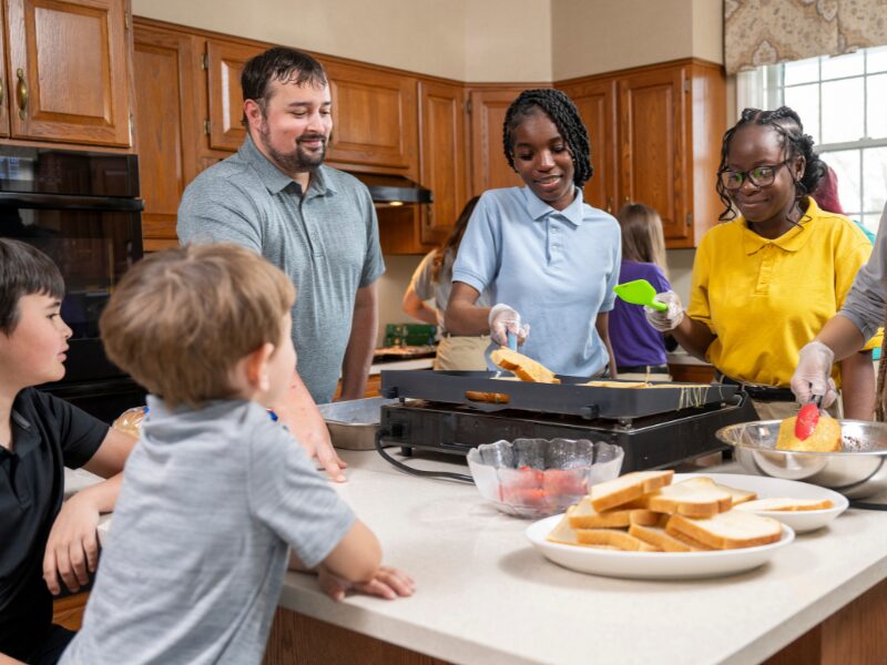 houseparents cooking breakfast with their students and personal children
