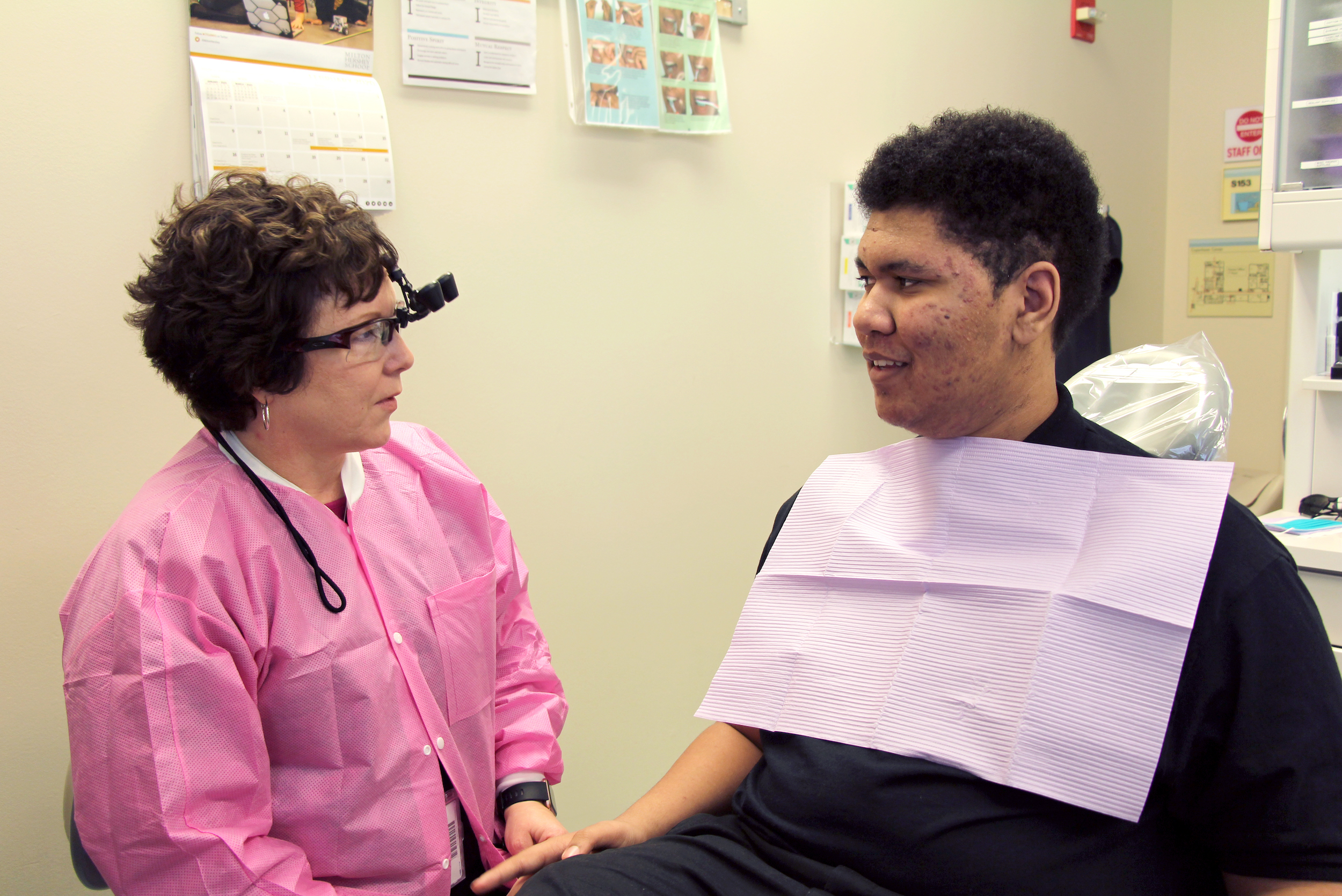 Milton Hershey School student Davontae talks about oral health with his MHS dental hygienist, Karen before his treatment.