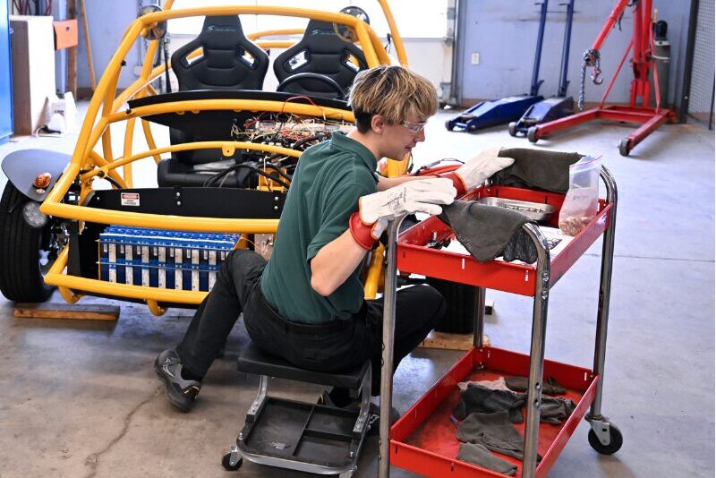 MHS engineering student working on car circuitry