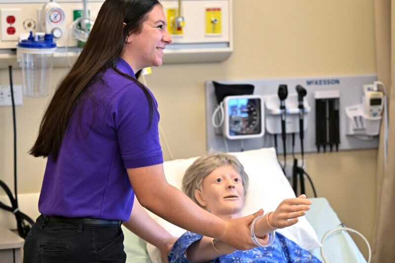MHS health science student with a medical training mannequin