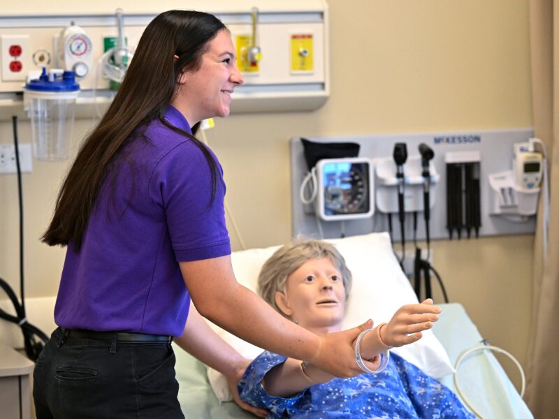 MHS health science student with a medical training mannequin