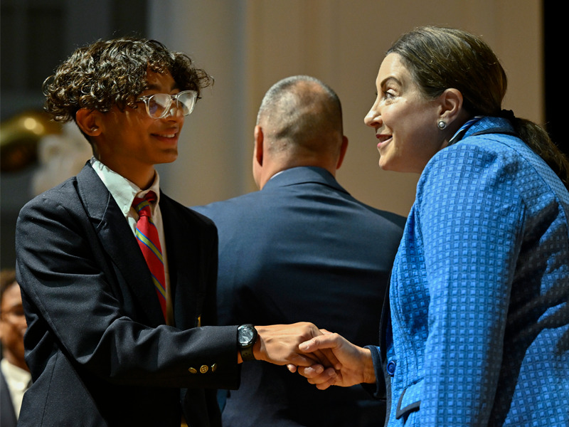 A student shakes an educator's hand during the MHS 2023 Eighth Grade Promotion Ceremony.