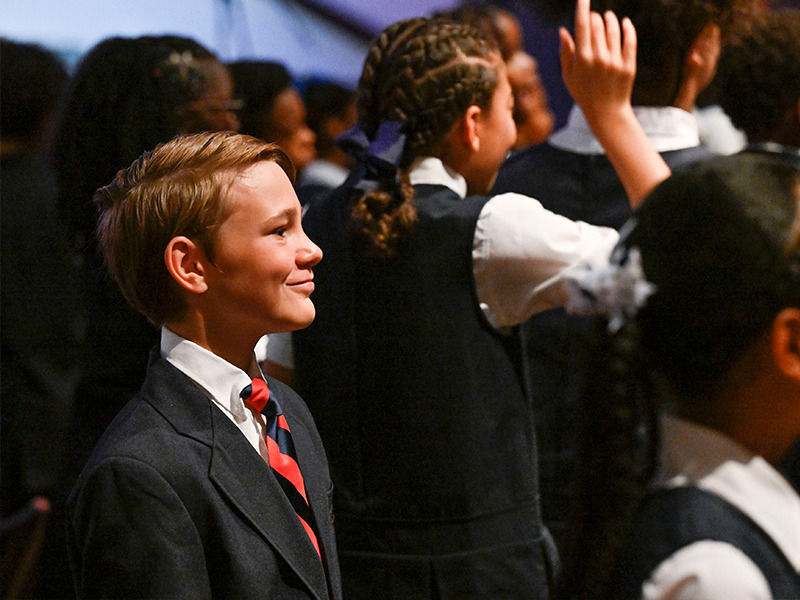 Milton Hershey School student smiles from the crowd during the 2023 Fourth-Grade Promotion Ceremony.