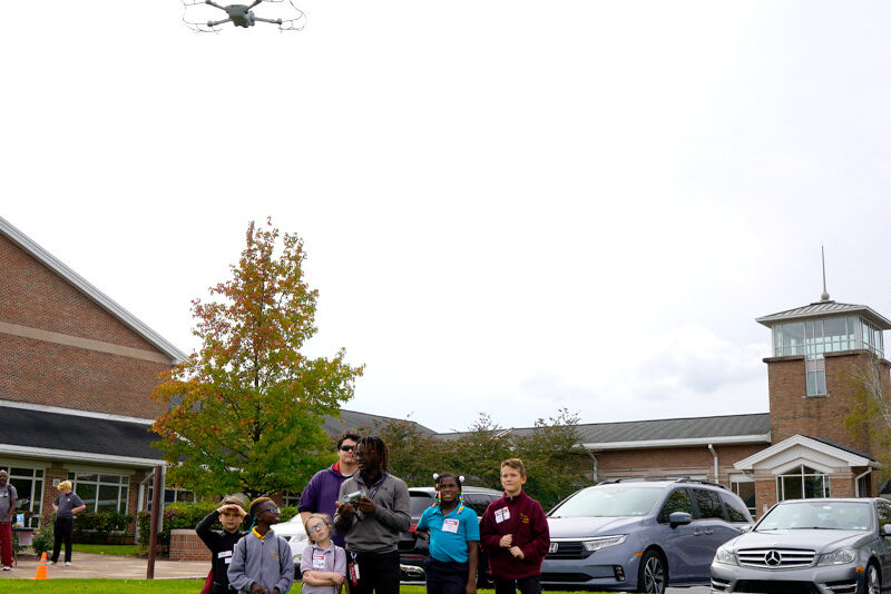 Milton Hershey School senior Alhaji Saccoh shows elementary students a skill he learned in drone class.