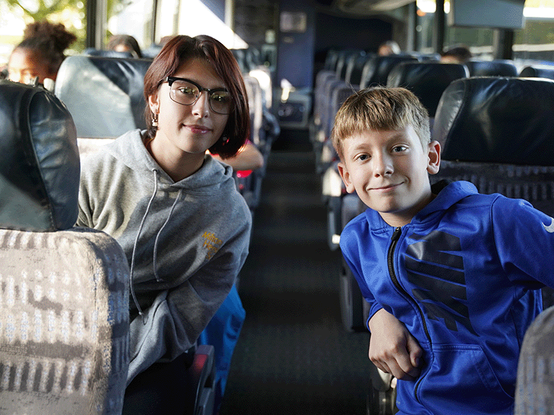 Milton Hershey School students sit aboard a charter bus on their way to their home communities for a school break.