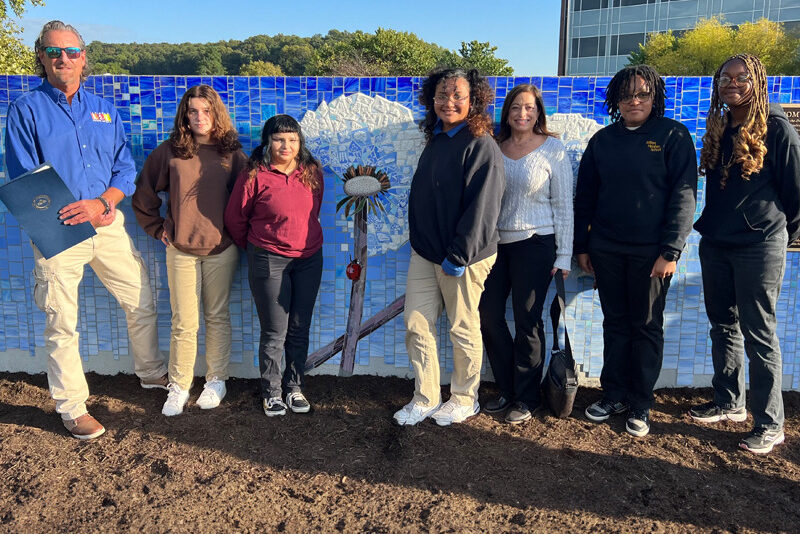 Milton Hershey School art students stand in front of a mural recently unveiled in Hershey, Pa.
