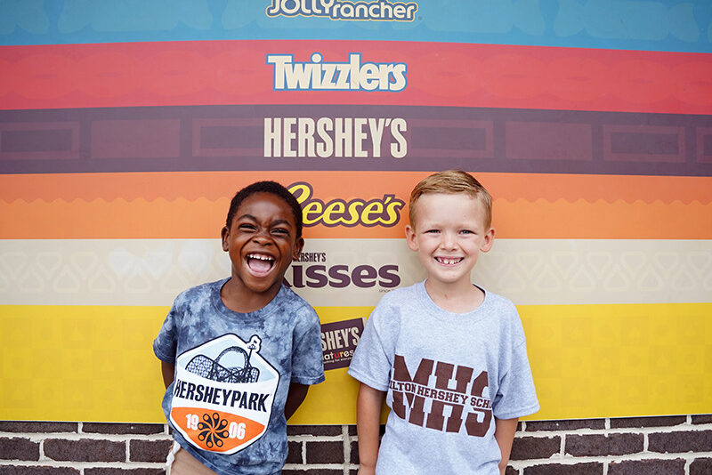 two children standing in front of a sign