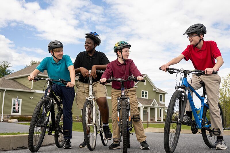 Middle school students outside of student home on bikes