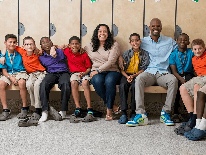 Milton Hershey School houseparents, Phil and Erica Clark, sit with their students in their student home.