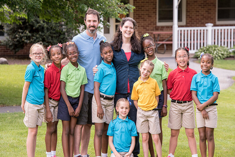 Milton Hershey School houseparents with students outside of student home