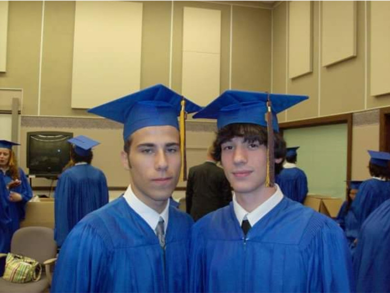 a couple of young men wearing graduation caps