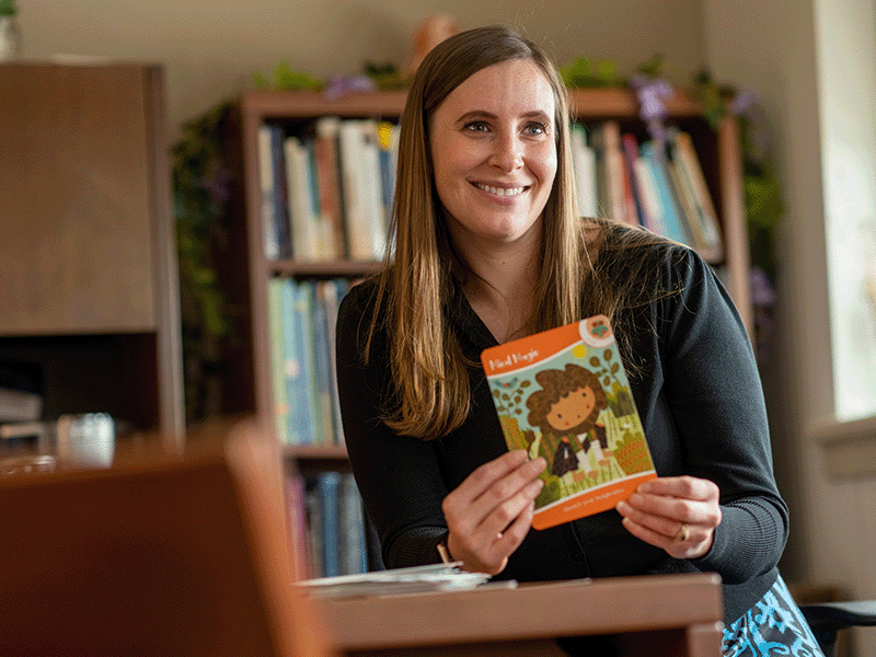 Milton Hershey School psychologist Allison Carrier sits with a book. 