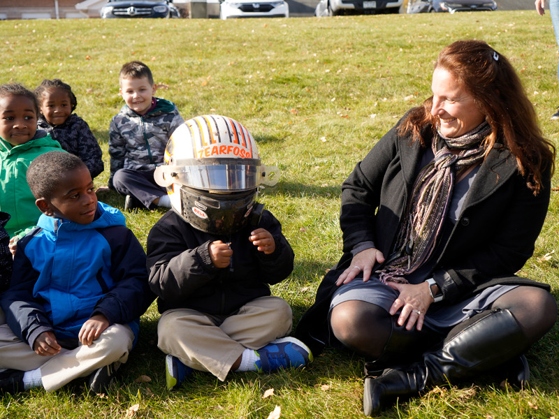 A Milton Hershey School student tries on Brock Zearfoss' helmet after hearing his lessons in success.