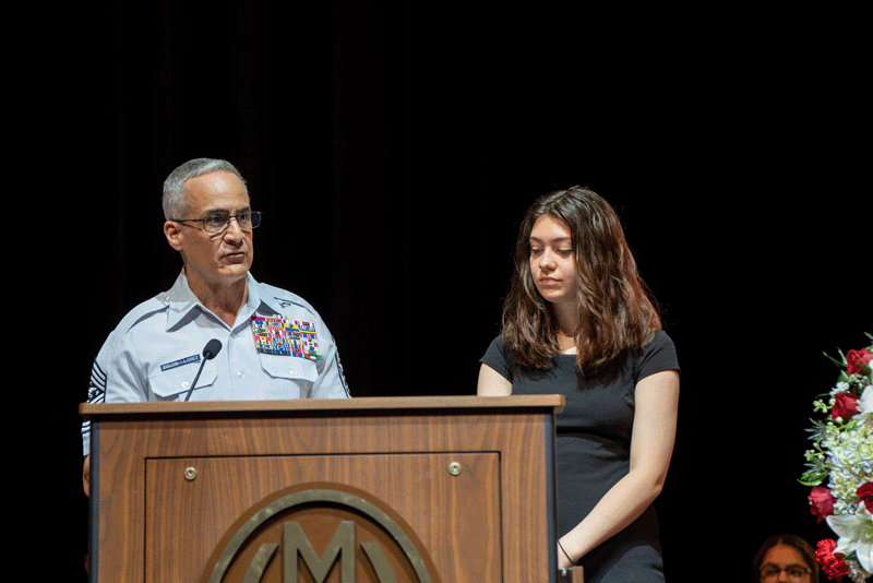 SEAC Ramón "CZ" Colón-López presents MHS senior Naveah Heverling with a challenge coin during the school's Memorial Day Assembly.