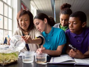 Milton Hershey School science teacher with students sitting around a project.