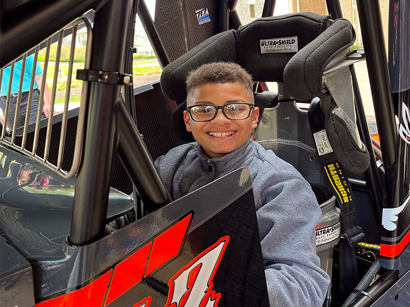 Milton Hershey School student sits in World of Outlaws race car