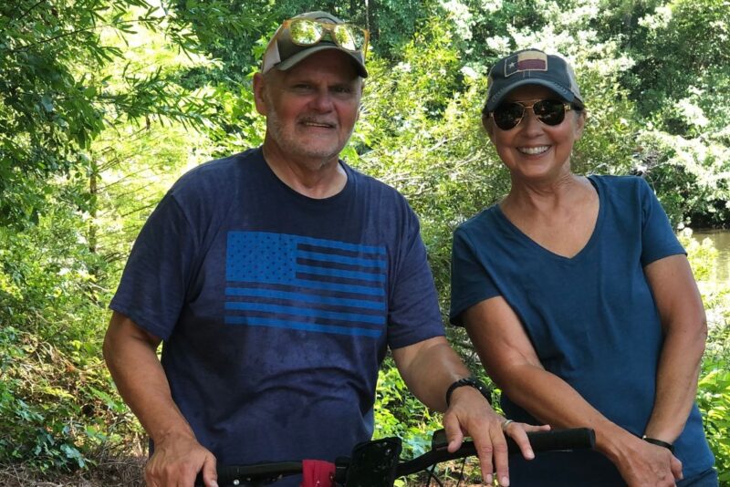 Houseparents Tarrant (Terry) and his wife Kathleen (Kathy) Augustine standing in nature.