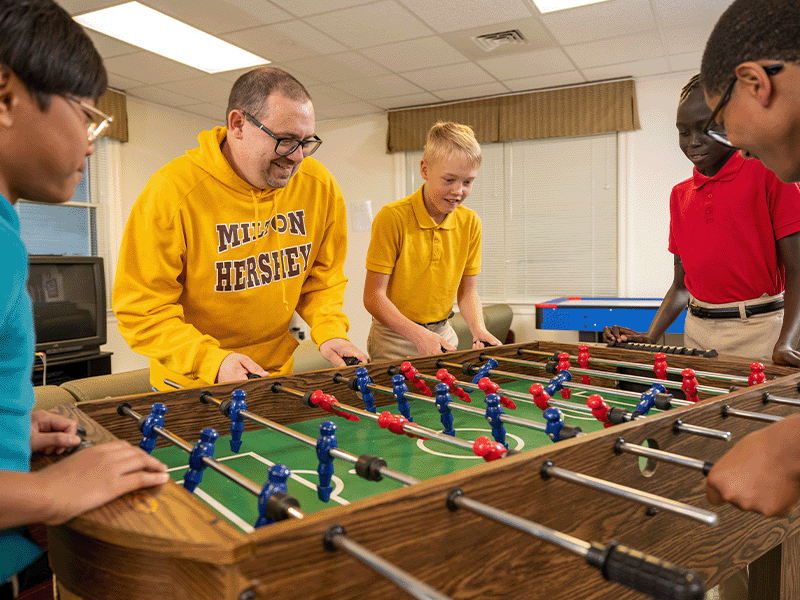 Milton Hershey School students play games with their houseparent.