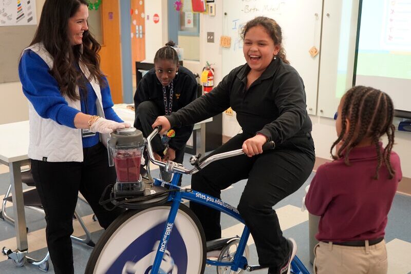 Milton Hershey School students ride the Penn State Health Smoothie Bike during a lesson on wholesome food.