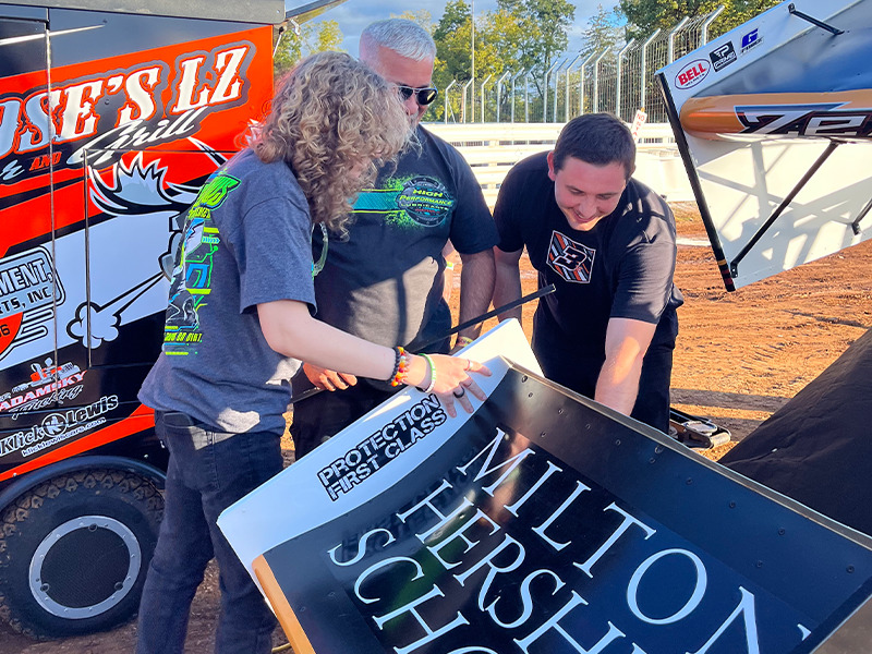 Milton Hershey School Senior Division student Mecca Stevers works with the team of Brock Zearfoss as they raced with the World of Outlaws.